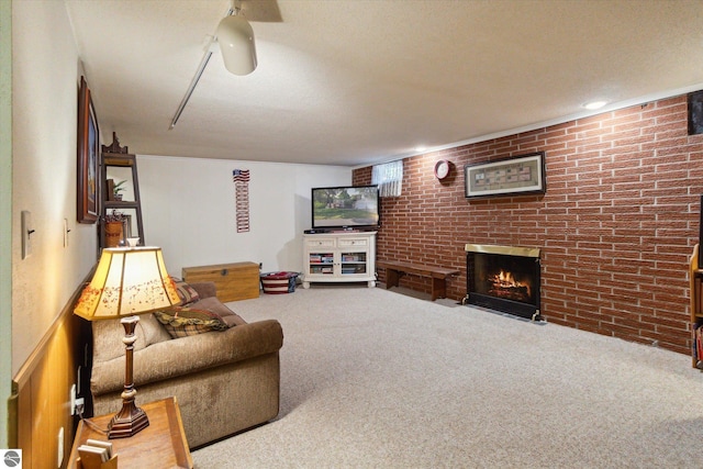 living room featuring a textured ceiling, a fireplace, carpet, and brick wall