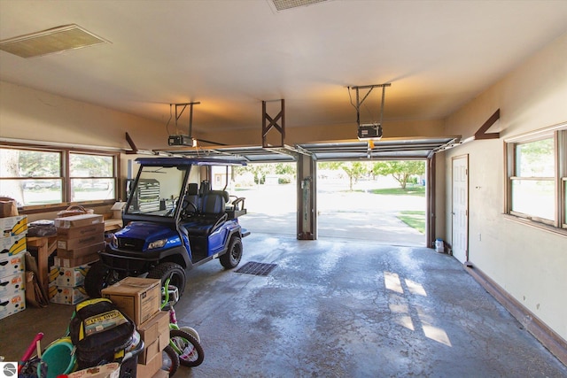 garage with baseboards, visible vents, and a garage door opener