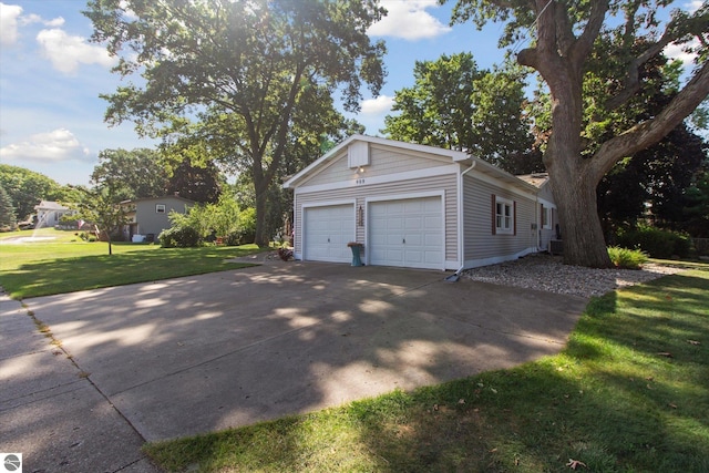 exterior space featuring a lawn, an attached garage, and concrete driveway