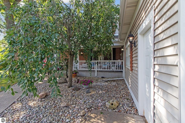 view of home's exterior with covered porch and brick siding