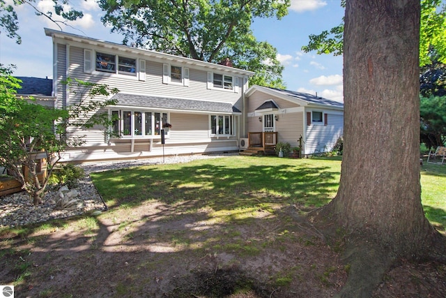 rear view of property featuring a lawn