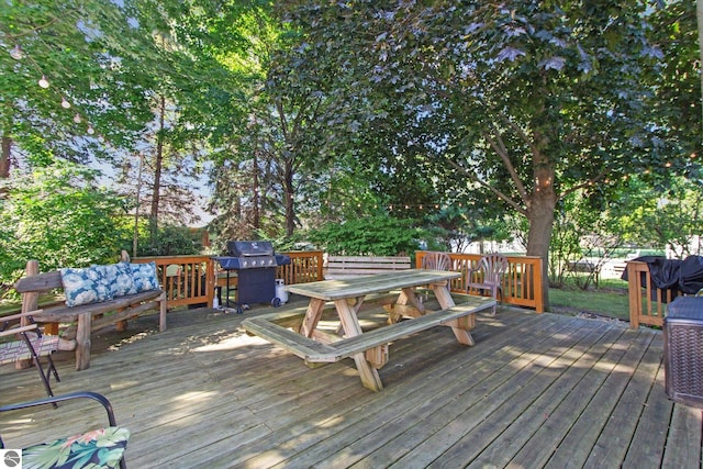 wooden deck with outdoor dining area and a grill