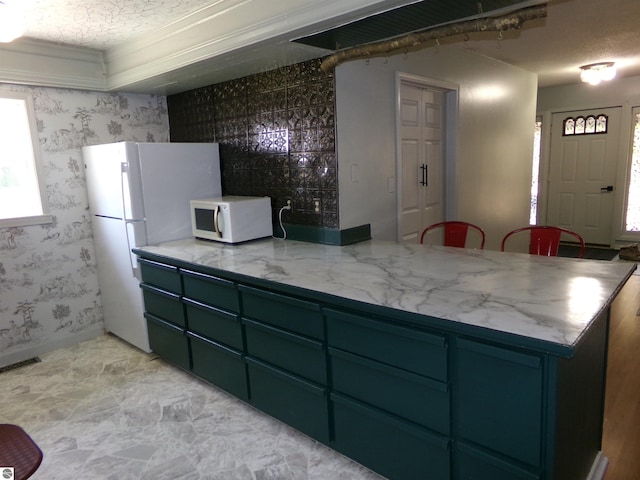 kitchen with wallpapered walls, white appliances, green cabinets, a peninsula, and visible vents
