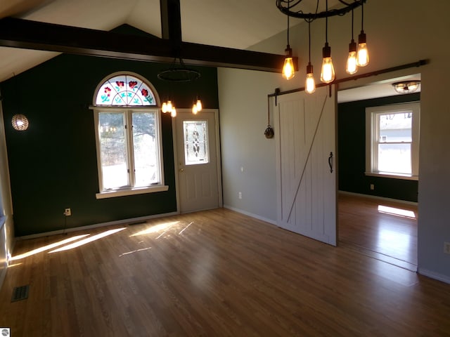entryway featuring a barn door, baseboards, wood finished floors, and visible vents