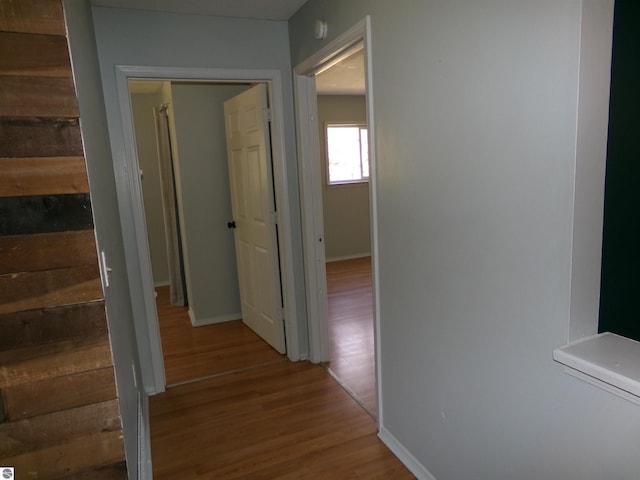 hall with wood finished floors and baseboards