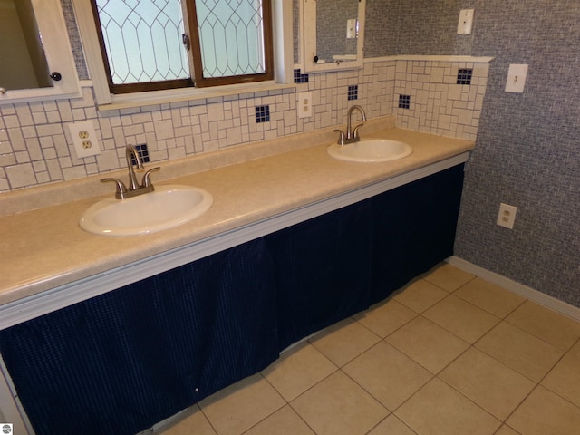 bathroom featuring tile patterned flooring, a sink, backsplash, and double vanity