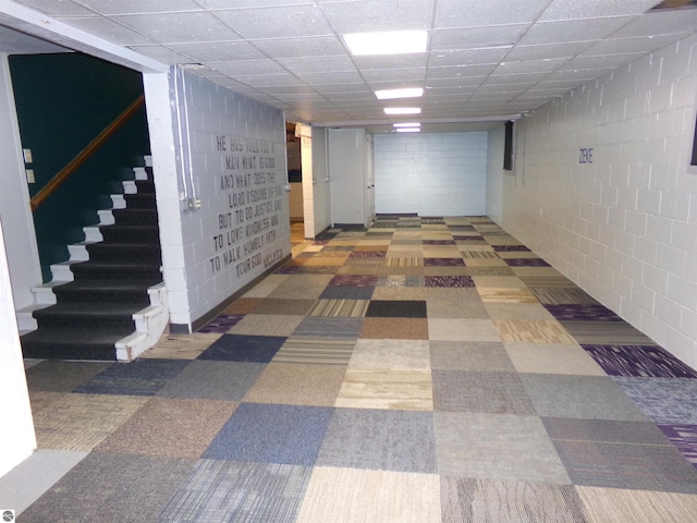 corridor featuring concrete block wall and a drop ceiling