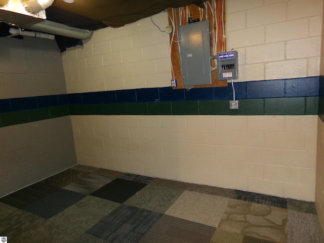 interior space with concrete block wall and electric panel