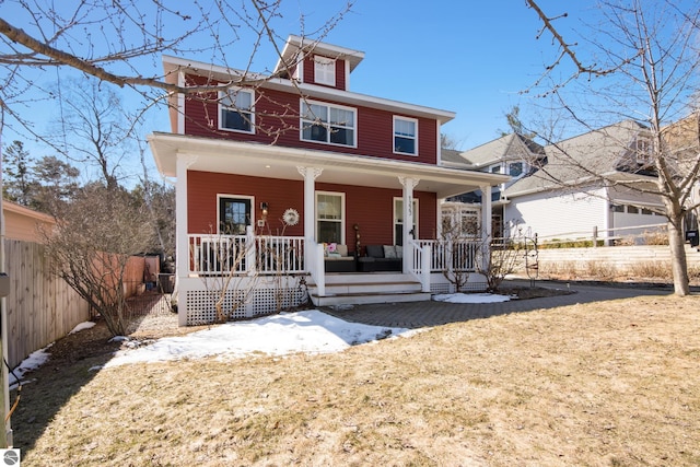 american foursquare style home with a porch and fence