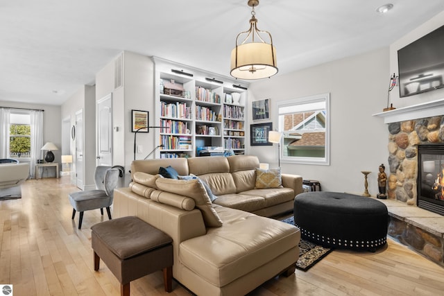 living area with wood-type flooring, plenty of natural light, and a fireplace