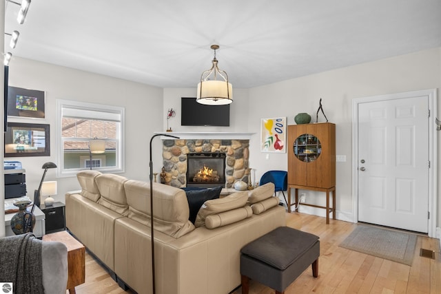 living area with light wood-style flooring and a fireplace