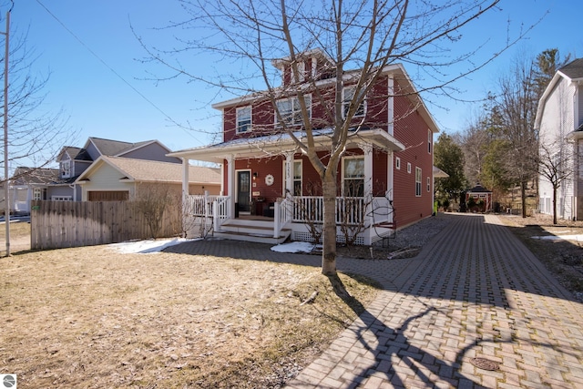 traditional style home with covered porch and fence