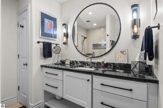 full bathroom featuring vanity, a tile shower, and recessed lighting