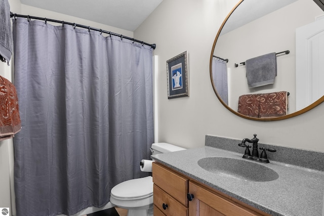 bathroom with toilet, vanity, and curtained shower