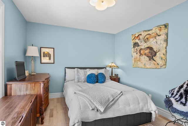 bedroom with light wood finished floors and baseboards