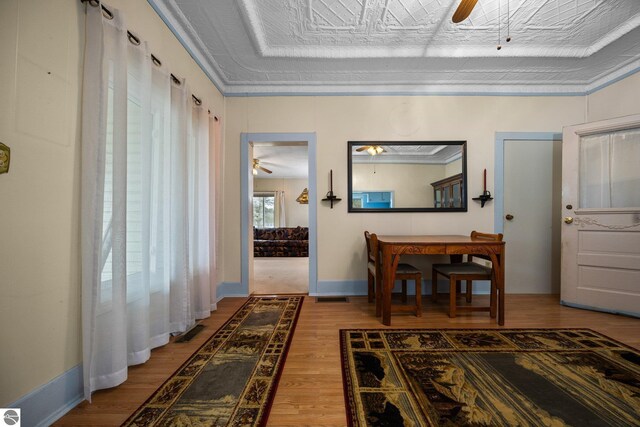 corridor featuring baseboards, visible vents, and wood finished floors