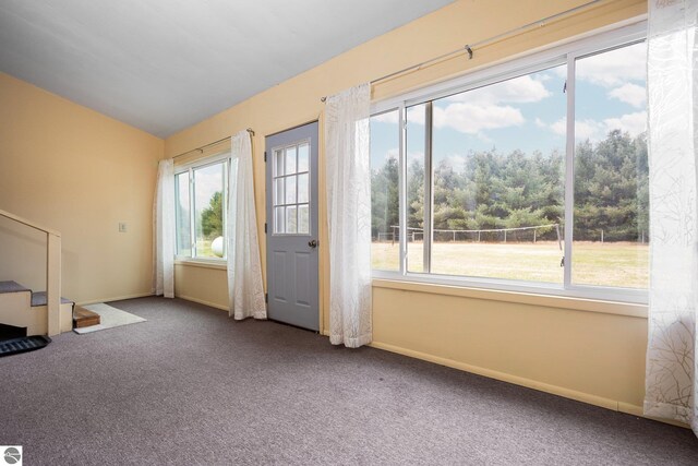 interior space featuring carpet floors, stairway, vaulted ceiling, and a wealth of natural light
