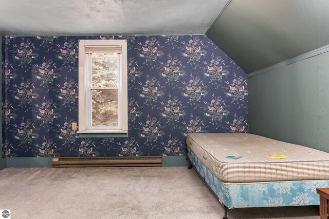 unfurnished bedroom with a baseboard radiator, vaulted ceiling, wallpapered walls, and carpet