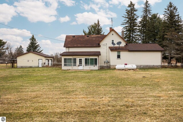 back of house with a lawn, a chimney, fence, and roof with shingles