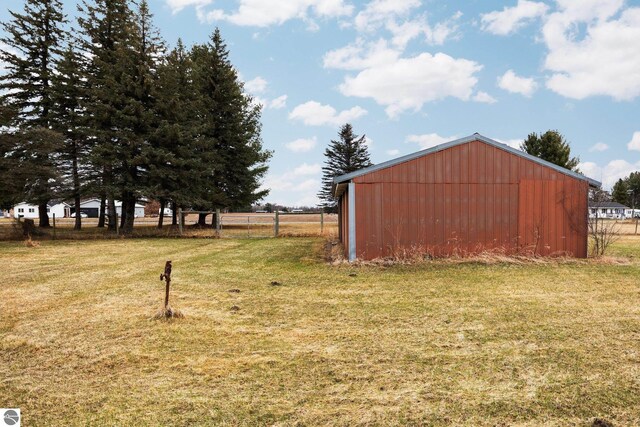 view of yard with an outbuilding, fence, and an outdoor structure