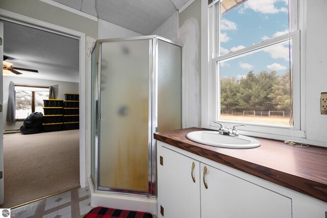 full bathroom featuring a baseboard radiator, a ceiling fan, tile patterned floors, and a shower stall