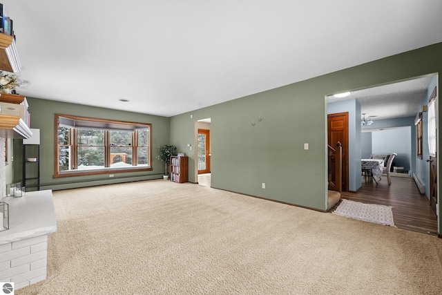 800 Evart St, Cadillac, MI 49601 - unfurnished living room featuring carpet floors, baseboards, and a baseboard heating unit