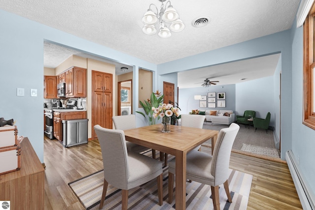 800 Evart St, Cadillac, MI 49601 - dining space featuring a textured ceiling, visible vents, light wood-type flooring, and a baseboard radiator