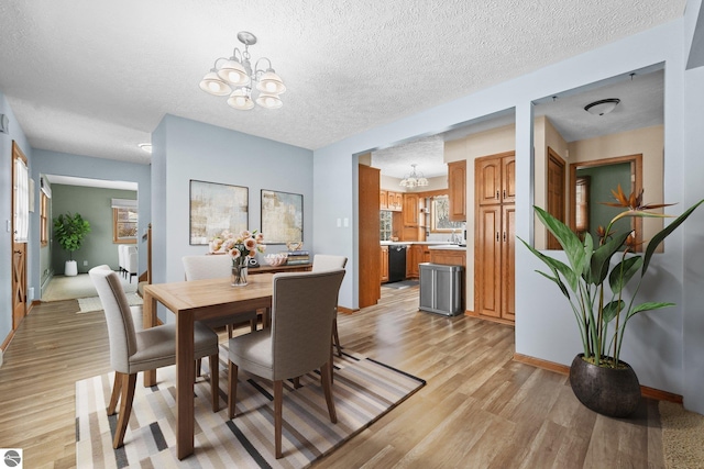 800 Evart St, Cadillac, MI 49601 - dining space featuring a textured ceiling, an inviting chandelier, baseboards, and light wood-type flooring