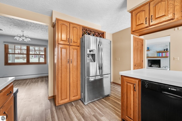 800 Evart St, Cadillac, MI 49601 - kitchen with stainless steel fridge with ice dispenser, light wood-style floors, light countertops, dishwasher, and a textured ceiling