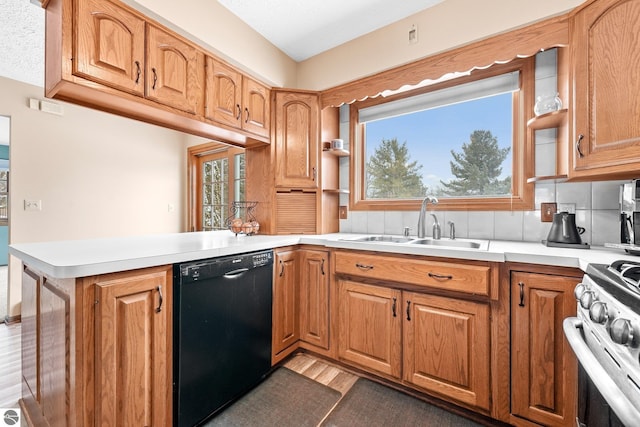 800 Evart St, Cadillac, MI 49601 - kitchen with dishwasher, a sink, light countertops, stainless steel gas range, and a peninsula