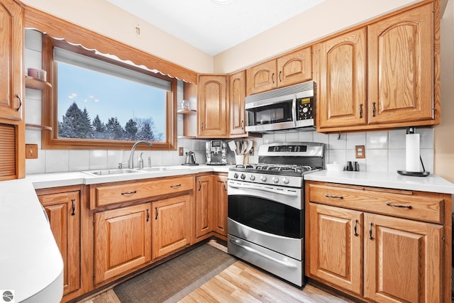800 Evart St, Cadillac, MI 49601 - kitchen with tasteful backsplash, a sink, light countertops, stainless steel appliances, and light wood-type flooring