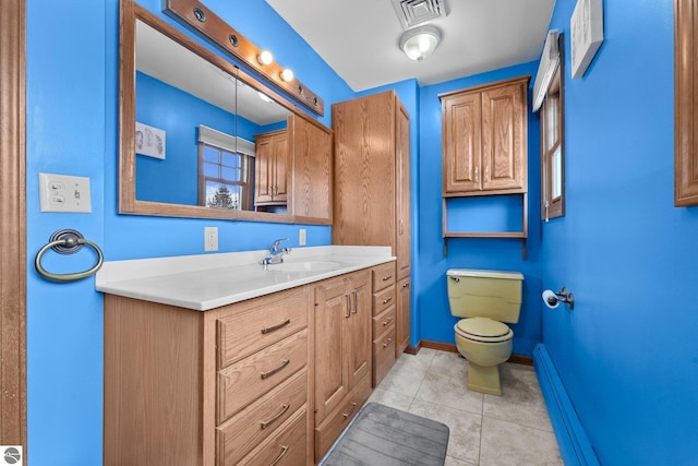800 Evart St, Cadillac, MI 49601 - bathroom featuring tile patterned flooring, vanity, toilet, baseboards, and visible vents