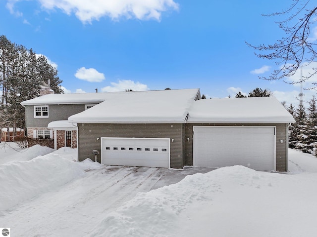 800 Evart St, Cadillac, MI 49601 - view of front of property with a garage and brick siding