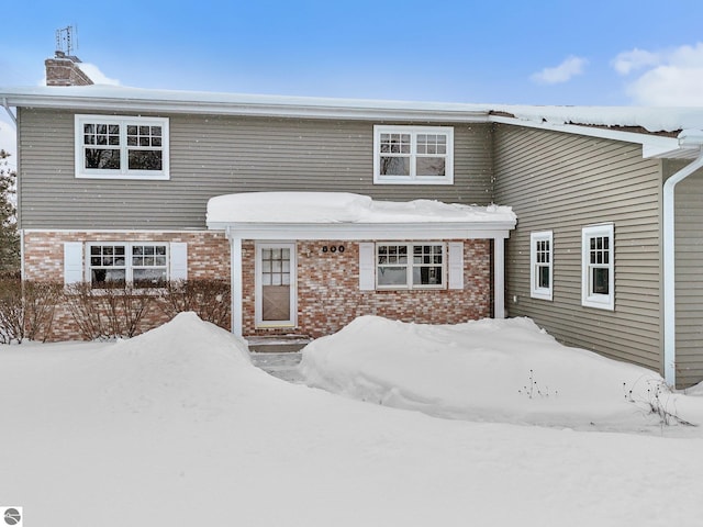 800 Evart St, Cadillac, MI 49601 - view of front facade featuring brick siding and a chimney