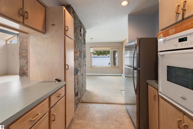 1137 Crystal Dr, Frankfort, MI 49635 - kitchen with oven, dark countertops, freestanding refrigerator, stone finish flooring, and a baseboard radiator