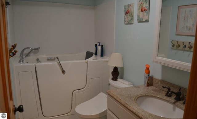 102 James Sq, Roscommon, MI 48653 - bathroom featuring toilet, vanity, and a bath