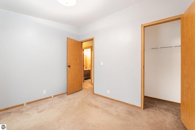 unfurnished bedroom with a closet, carpet flooring, and baseboards