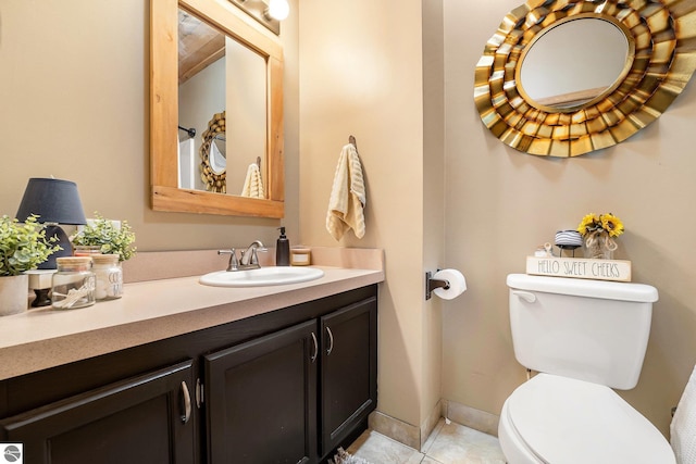 bathroom featuring baseboards, toilet, tile patterned flooring, and vanity
