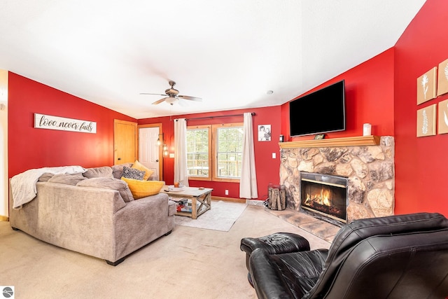 living area with a stone fireplace, carpet, lofted ceiling, and ceiling fan