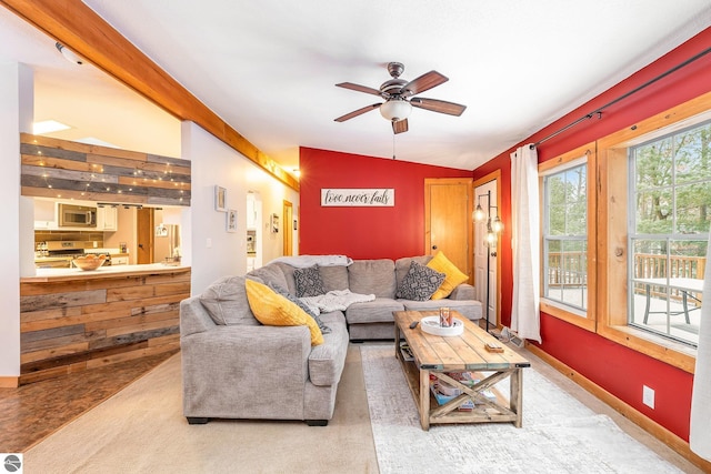 living room with baseboards and ceiling fan