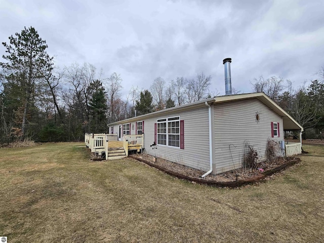 view of home's exterior with a yard and a wooden deck