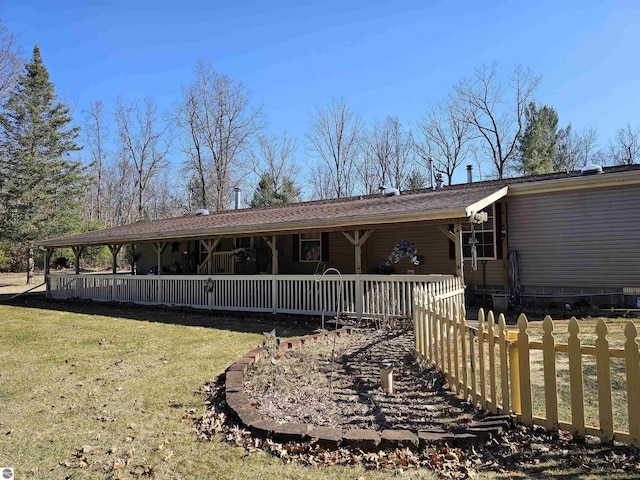 back of property featuring a porch, fence, and a lawn