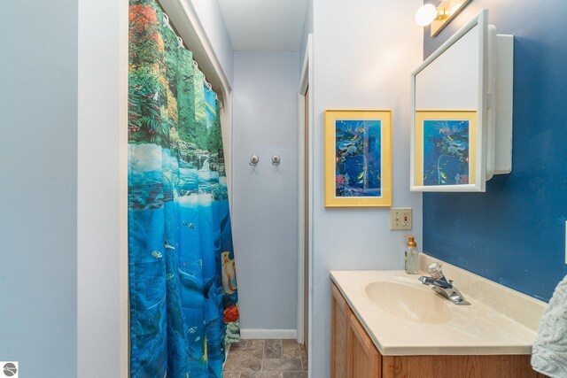 bathroom with baseboards, a shower with shower curtain, and vanity