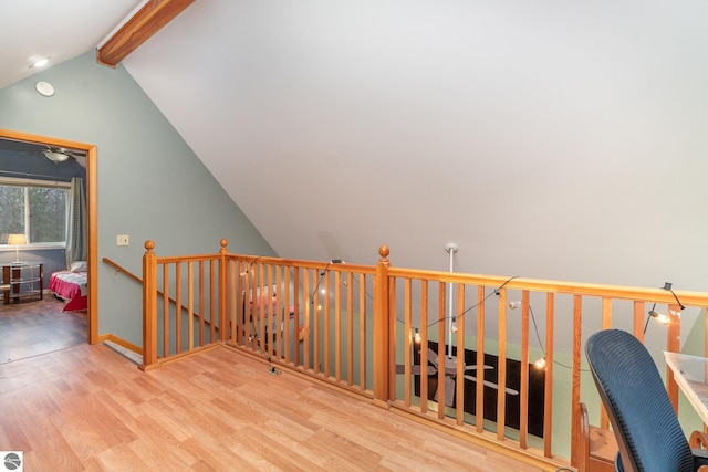 interior space with lofted ceiling with beams, baseboards, and wood finished floors