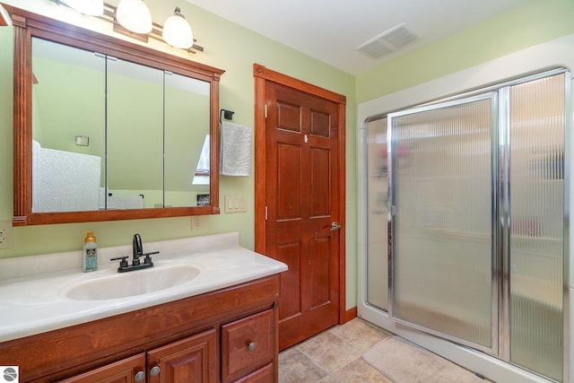 bathroom featuring vanity, visible vents, and a shower stall