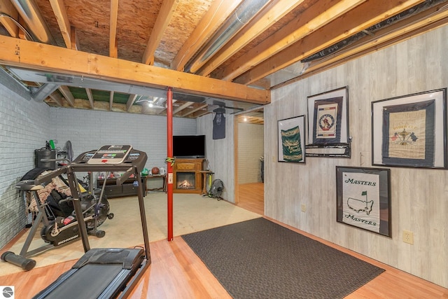 workout room with wood finished floors and brick wall