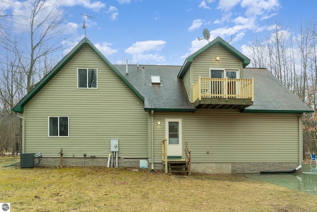 rear view of house with a balcony, a lawn, central AC, and entry steps