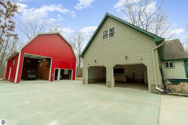 view of home's exterior with an outdoor structure and driveway