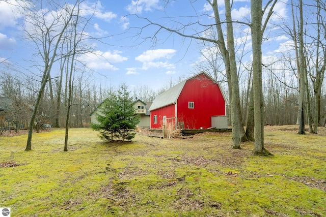 view of yard with an outbuilding, a detached garage, and a barn