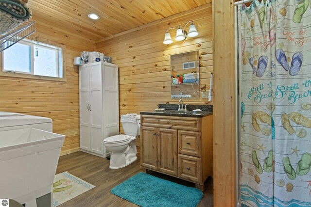 112 N Benzie Blvd, Beulah, MI 49617 - bathroom with wood finished floors, toilet, curtained shower, vanity, and wooden ceiling